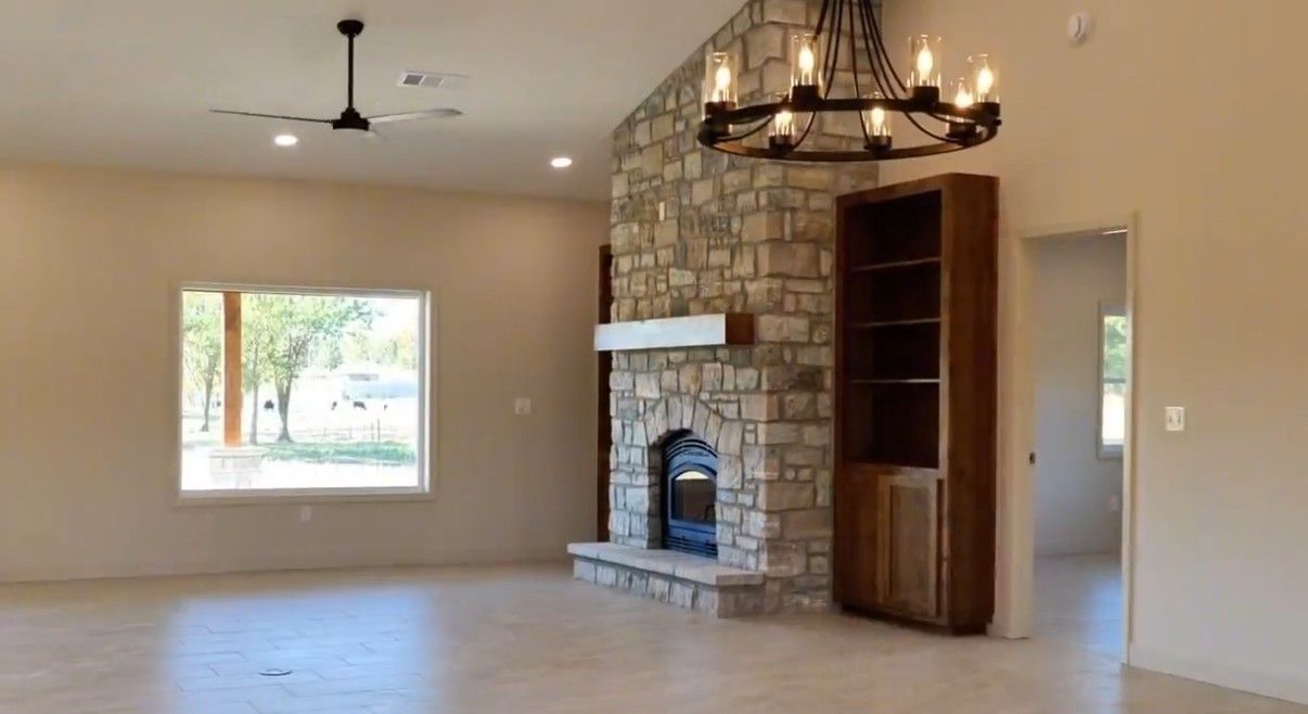 Living room with floor-to-ceiling stone fireplace and built-in shelving