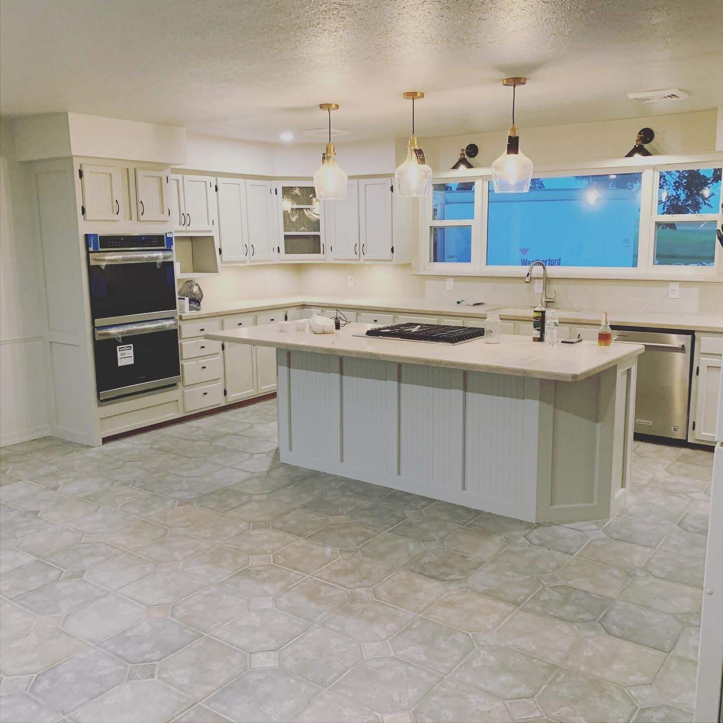 Kitchen after remodel with painted cabinets and pendant lights