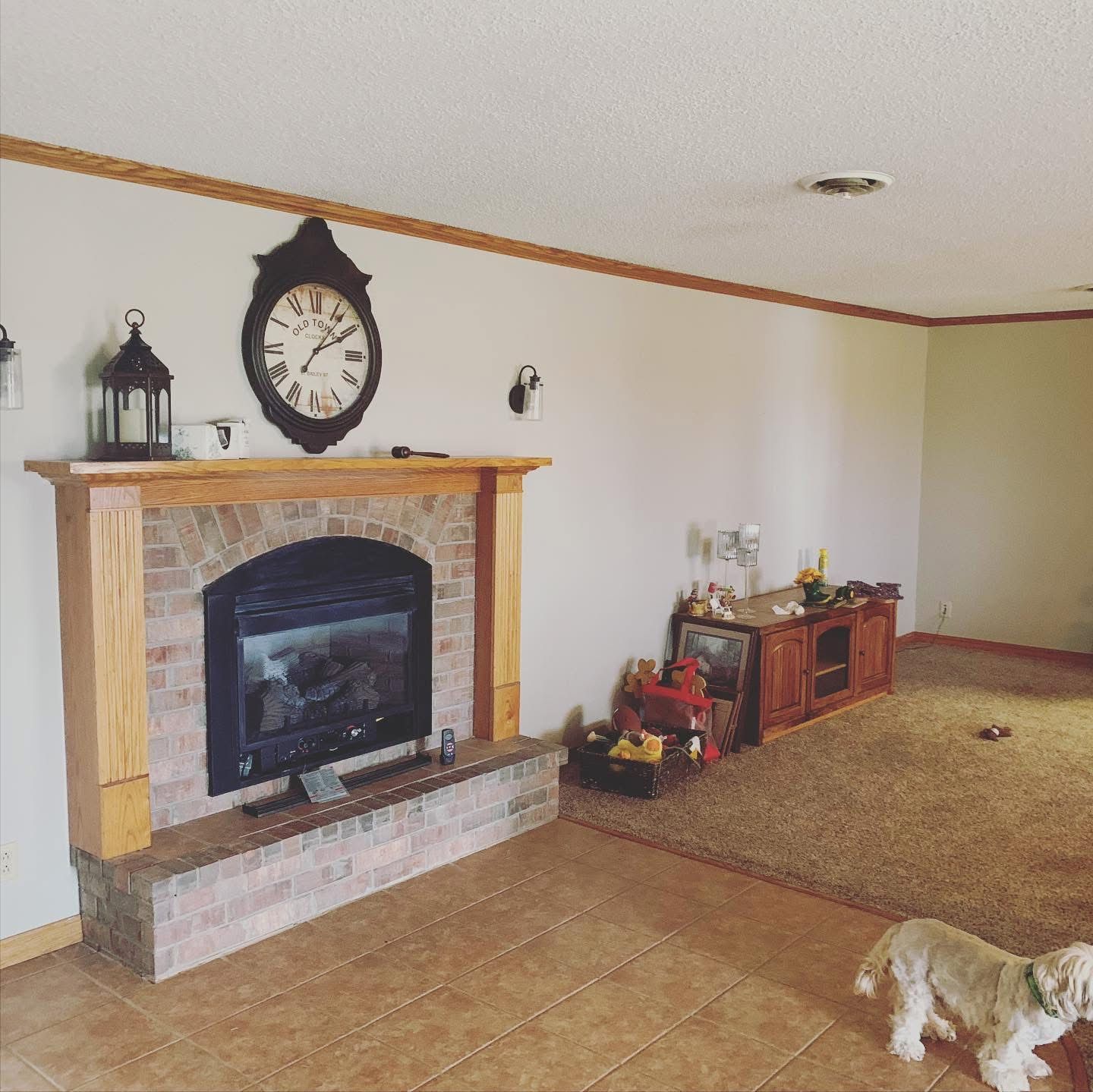 Living room before remodel with brick fireplace and carpet