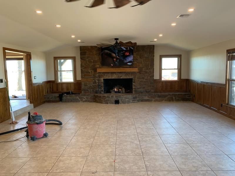 Same family room after remodel with painted walls, tile floor and updated stone fireplace